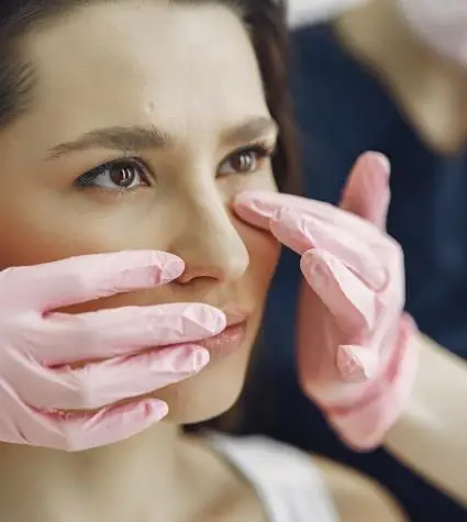 Patient is being examined by plastic surgeon for candidacy of a nose reshaping surgery