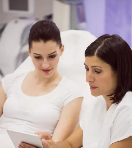 Plastic surgeon is discussing pathway for multiple area liposuction with a female patient