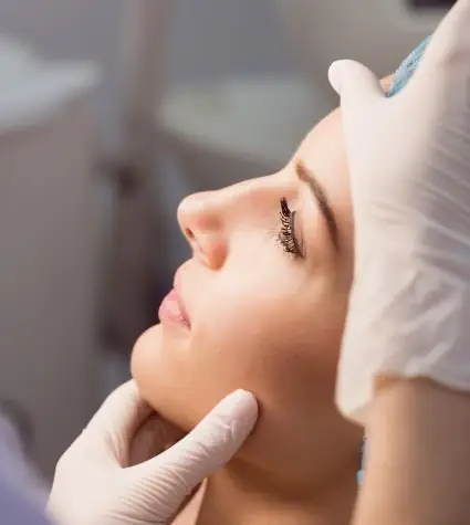 A plastic surgeon is examining woman patient face for neck and face lift 