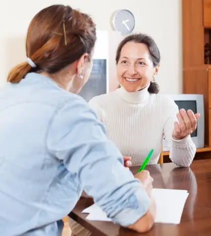 A woman patient in discussion with a plastic surgeon for mommy makeover plastic surgery